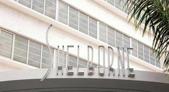 The entrance sign for The Shelborne by Proper in Miami Beach, FL with modern, stylized lettering; a palm tree is visible on the right.