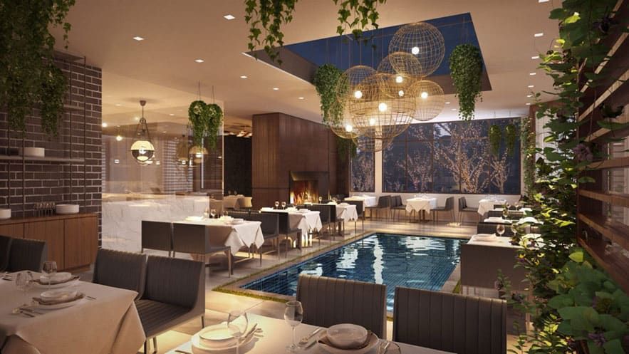 Ocean 48 - A modern restaurant interior with tables set for dining, a small central pool, hanging light fixtures, and green plants decorating the ceiling and walls.