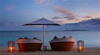 Virtual Background - Rosewood Baha Mar comfortable seats with umbrella and candle lights on the beach and dusk